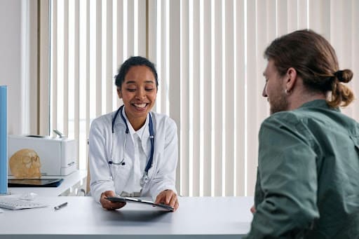 Doctor smiling as she reviews a treatment plan with her patient