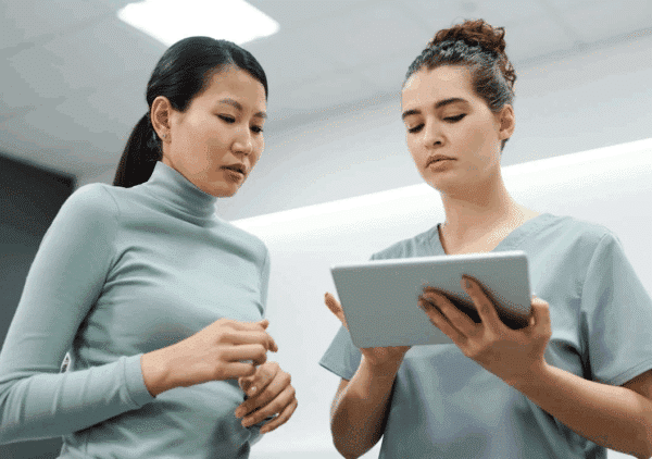 A doctor and patient looking at a tablet together.