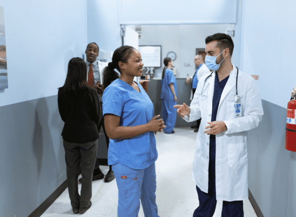 Doctor and nurse talking in hospital hallway