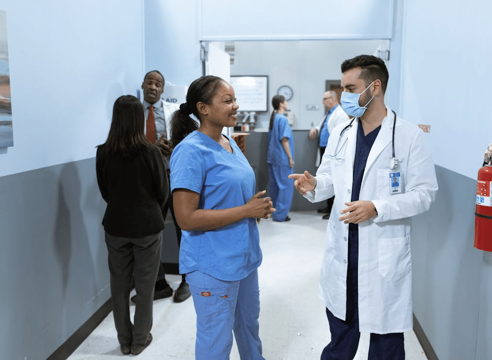 Doctor and nurse talking in hospital hallway