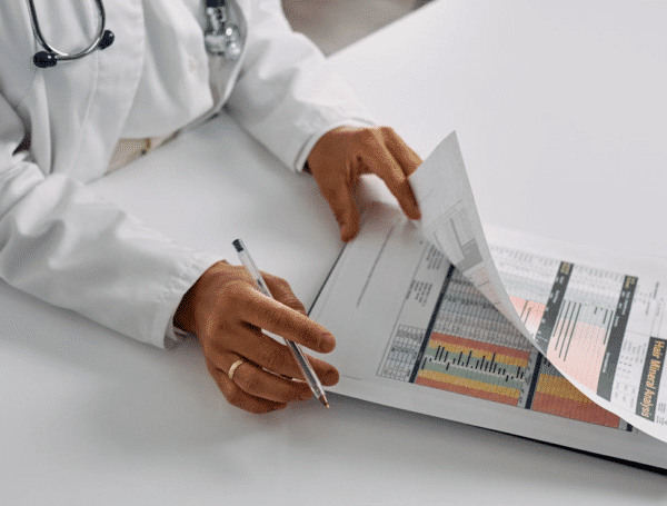 doctor with pen, reviewing data on clip board