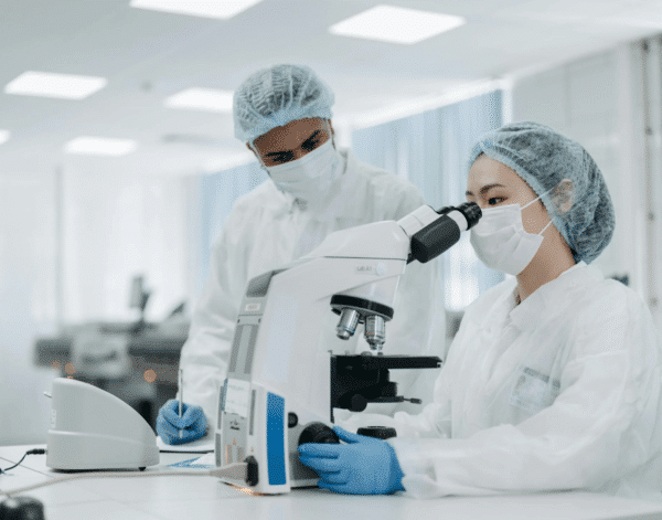 A team of scientists using magnifying equipment for genetic testing