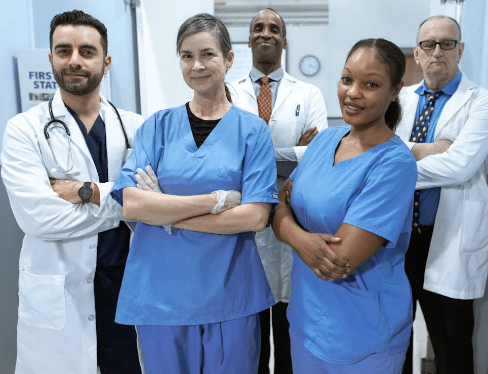 A physician group stood in a hallway, folding their arms and smiling