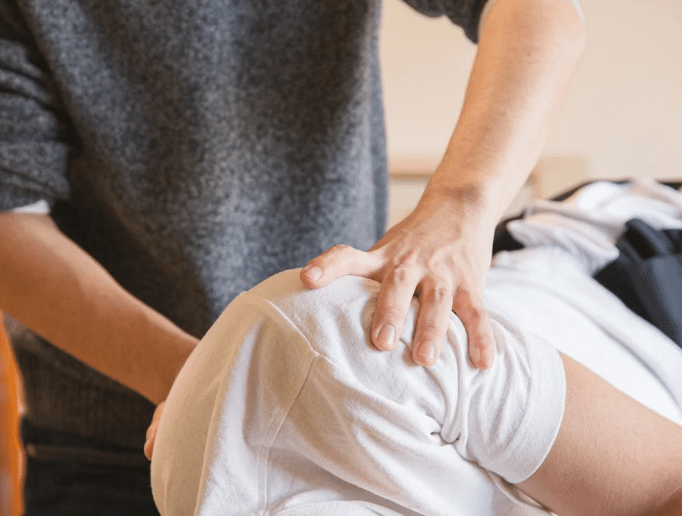 A masseur preparing a client for a spine treatment